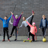 Kuvassa iloisia lapsia eri liikuntavälineiden kanssa