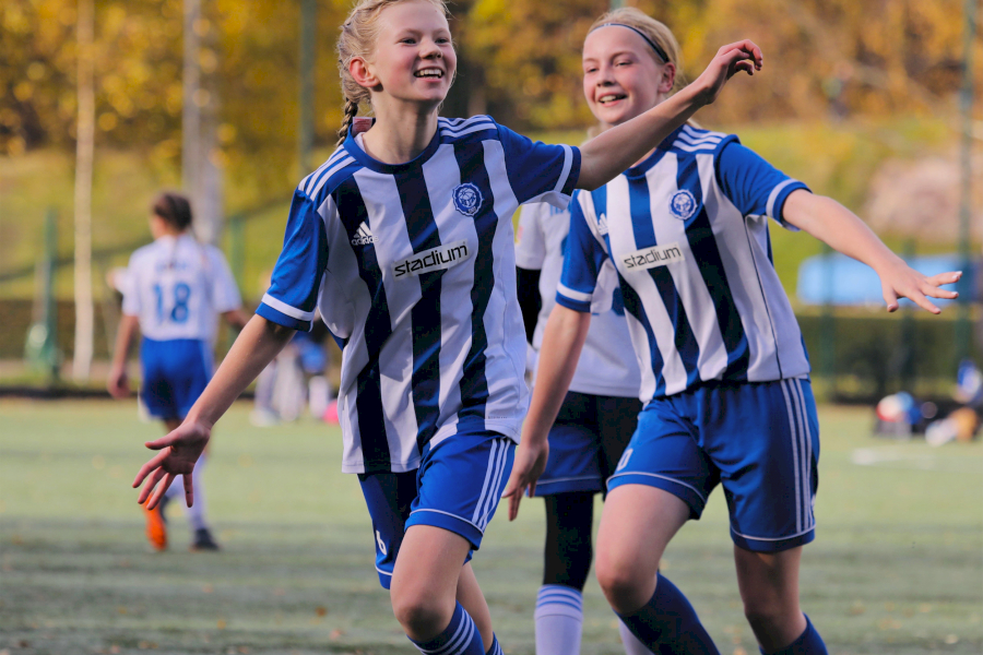 Nuori mieli urheilussa pääkuva: kaksi nuorta juoksevaa jalkapallonpelaajaa hymyilevät iloisena