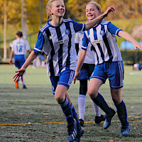 Nuori mieli urheilussa pääkuva: kaksi nuorta juoksevaa jalkapallonpelaajaa hymyilevät iloisena