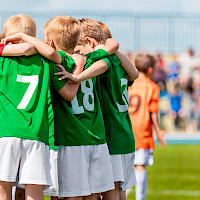 myClub-kuva, jossa nuorten jalkapallojoukku on kerääntynyt rinkiin kädet toistensa hartioilla.
