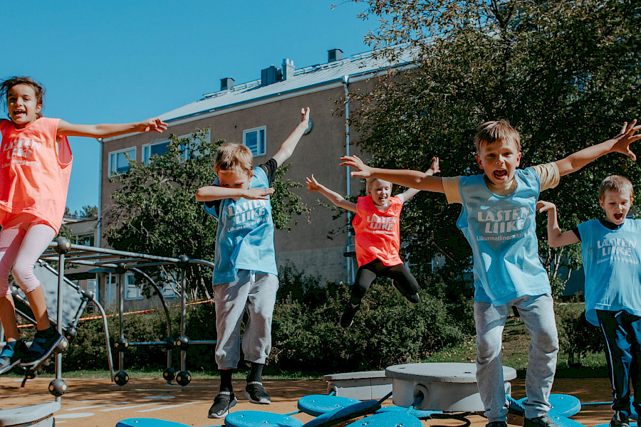 Iloiset lapset hyppäävät Lasten liike -liiveissään