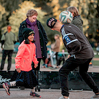 Tyttö ja poika kikkailevat jalkapallolla