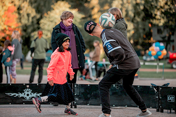 Tyttö ja poika kikkailevat jalkapallolla