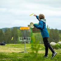 Lapsi heittämässä frisbeegolfia